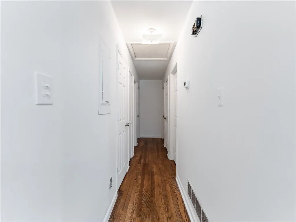 Hall featuring dark wood-style flooring and attic access