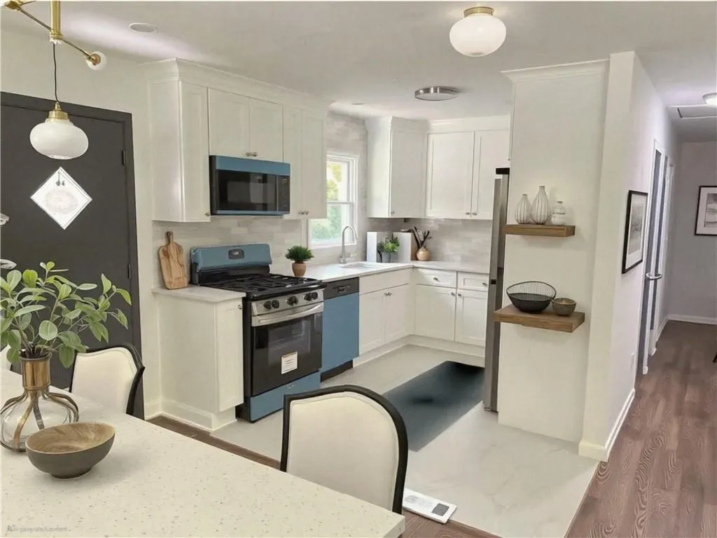 Kitchen with appliances with stainless steel finishes, white cabinets, light wood finished floors, pendant lighting, and decorative backsplash