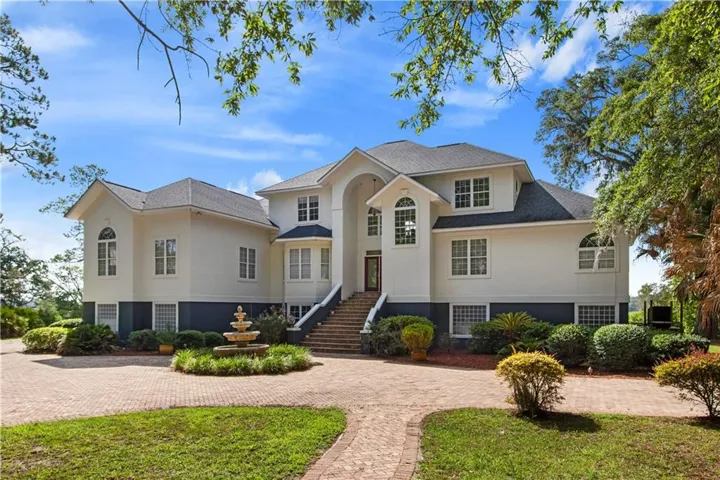 Grand exterior with a multi-level design and a brick paver driveway