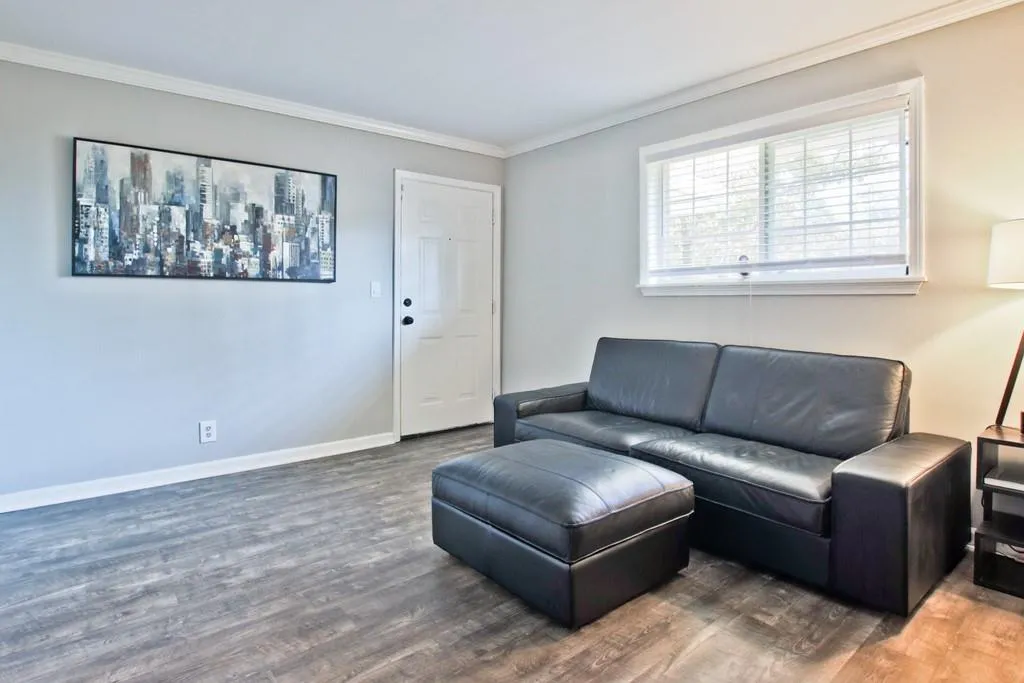 Living room with wood finished floors and ornamental molding