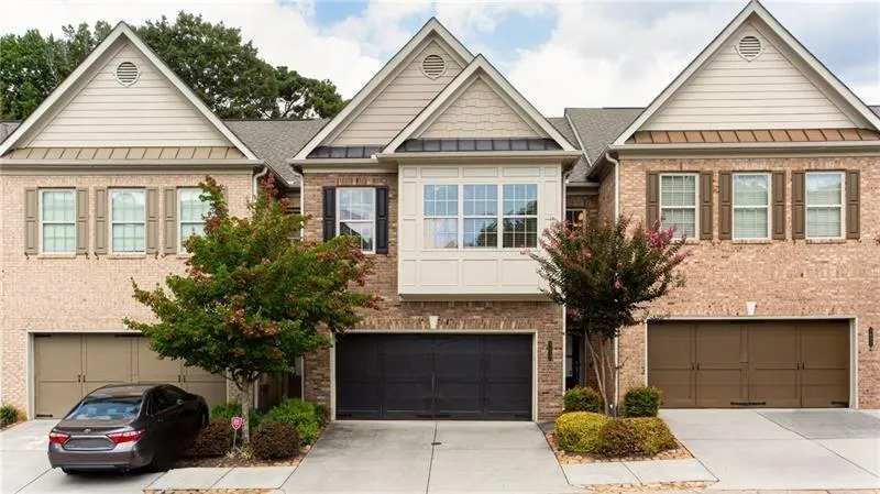 Craftsman-style home with a standing seam roof, a metal roof, brick siding, and driveway