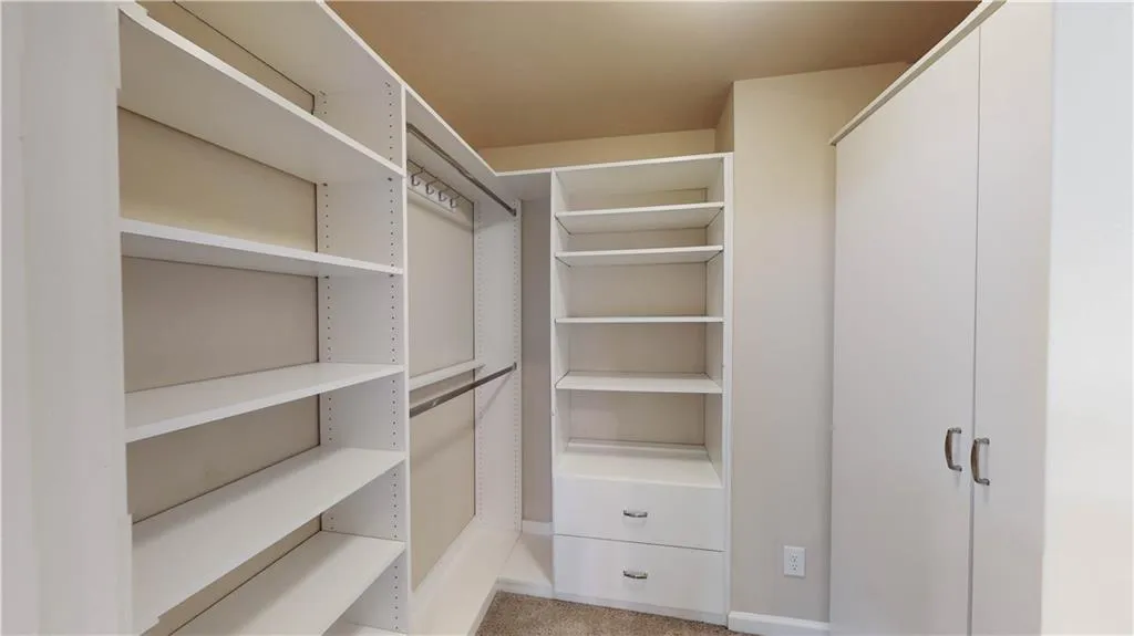 View of spacious master closet with closet system