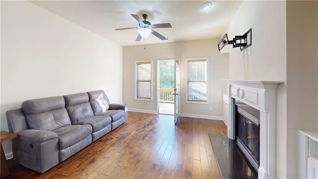 Living room with ceiling fan and dark hardwood / wood-style flooring