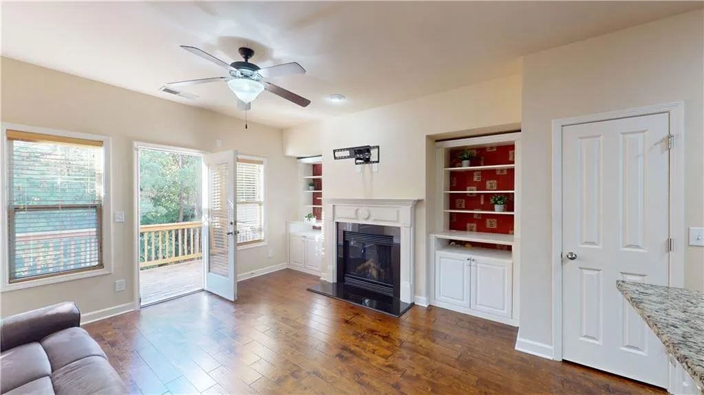 Unfurnished living room with ceiling fan and dark hardwood / wood-style floors