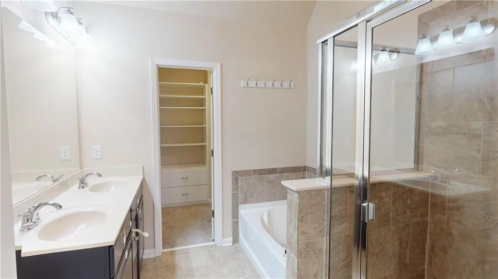 Master Bathroom featuring double vanity, independent shower and bath, and tile patterned flooring