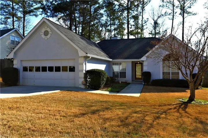 Light gray stucco exterior with dark shingle roofing