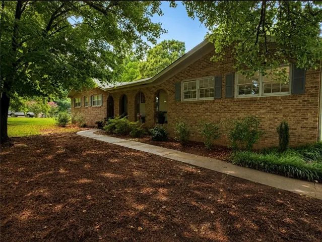 Brick exterior residence with a covered entryway featuring arched detailing