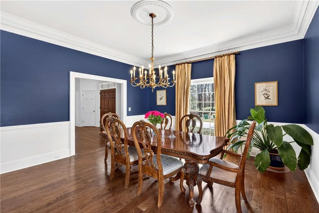 The spacious dining room, accented by beautiful navy walls, offers a rich and elegant setting for both intimate dinners and larger gatherings.