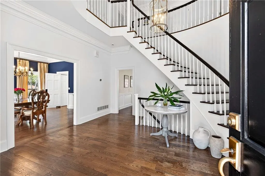 A dramatic two-story entry with a graceful winding staircase creates a stunning first impression and a true sense of arrival.