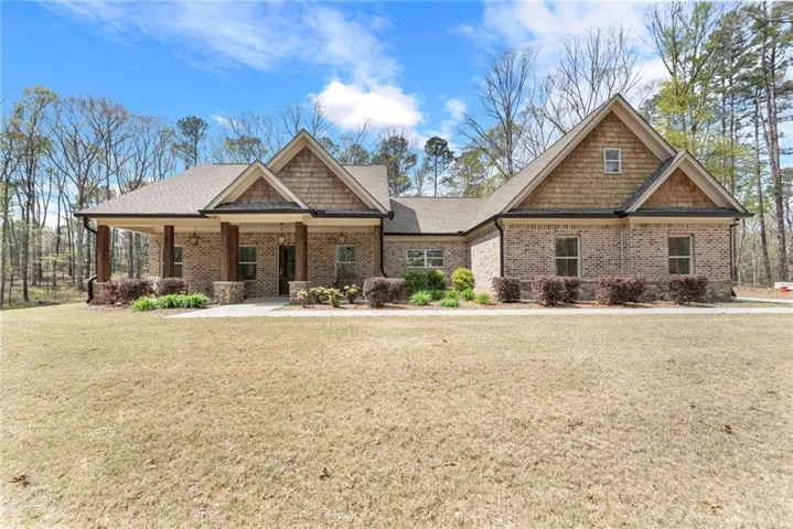 Craftsman house featuring a front lawn, brick siding, a porch, and a shingled roof