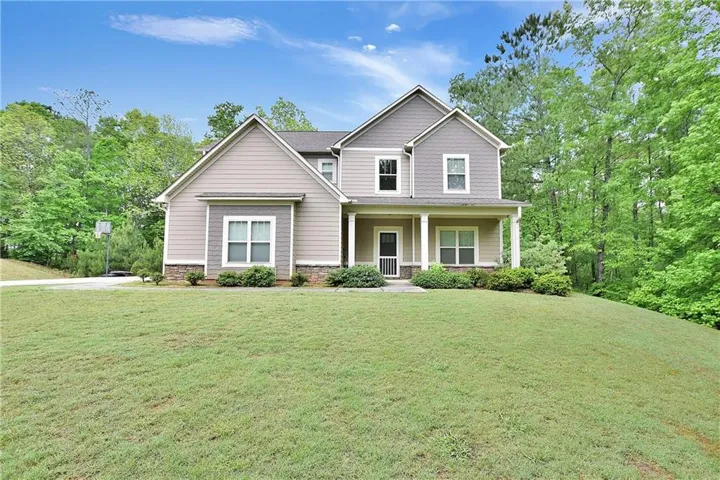 Two-story home with a covered front porch and a stone accent foundation