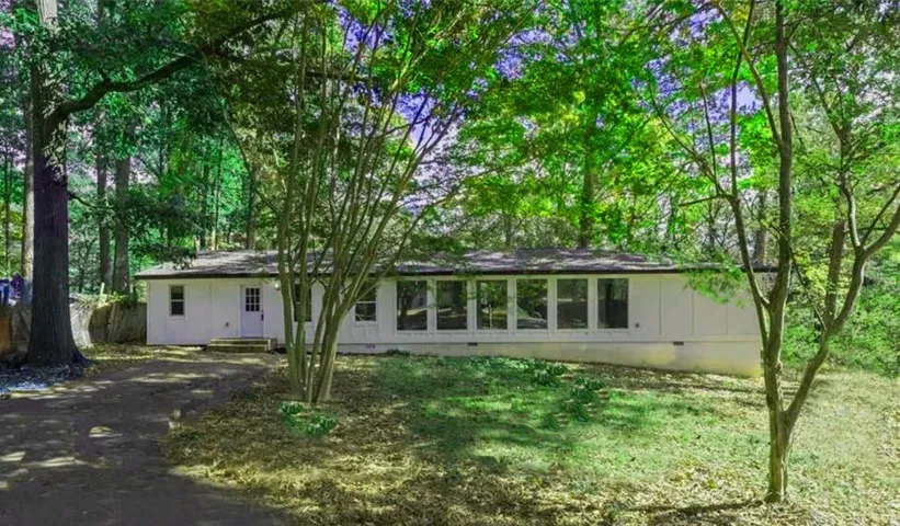 Rear view of property featuring crawl space, driveway, and entry steps