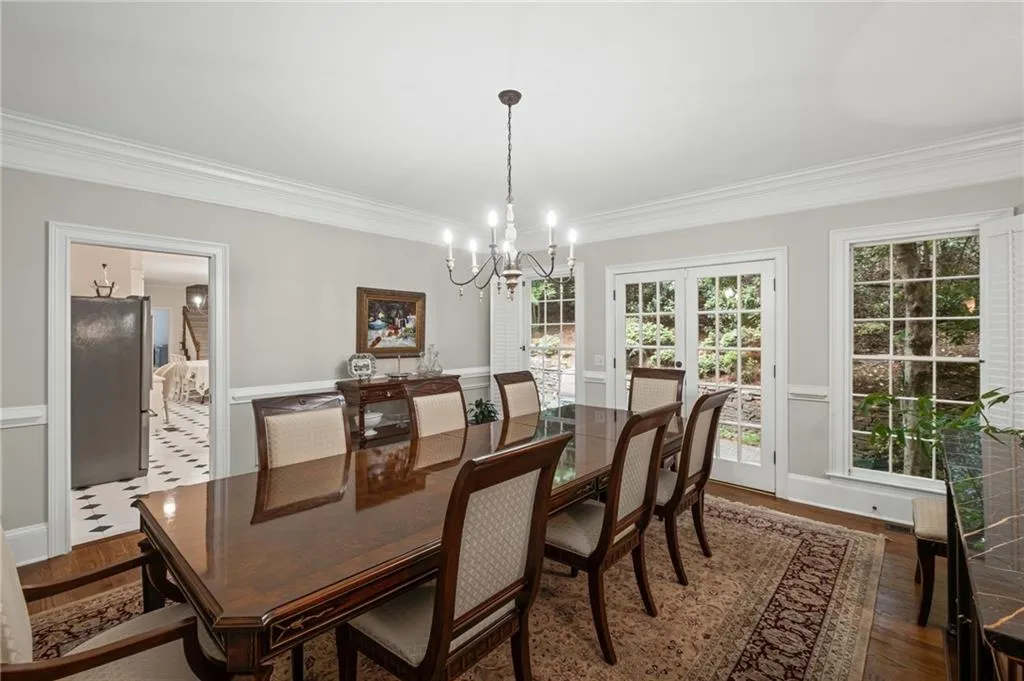 Dining space with a chandelier, crown molding, and dark wood finished floors