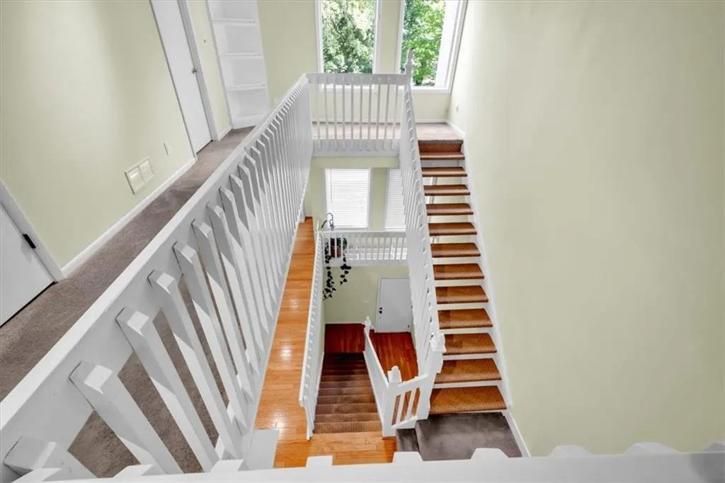 Stairs with a high ceiling and hardwood / wood-style floors