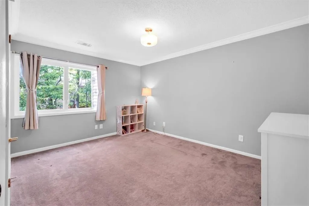 Carpeted spare room with crown molding