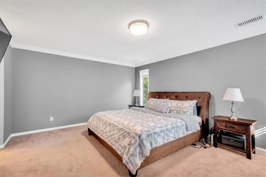 Bedroom with crown molding, a textured ceiling, and carpet floors