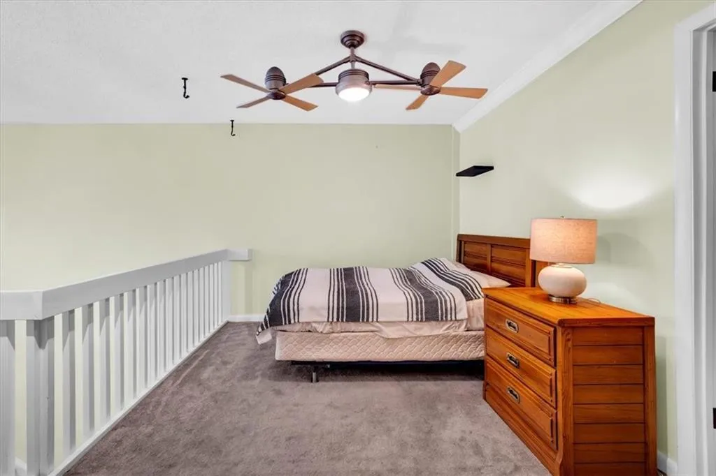 Carpeted bedroom featuring crown molding and ceiling fan