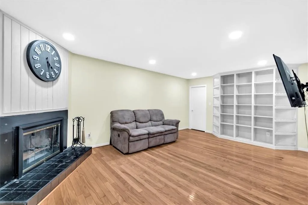 Living room with a tile fireplace and hardwood / wood-style floors
