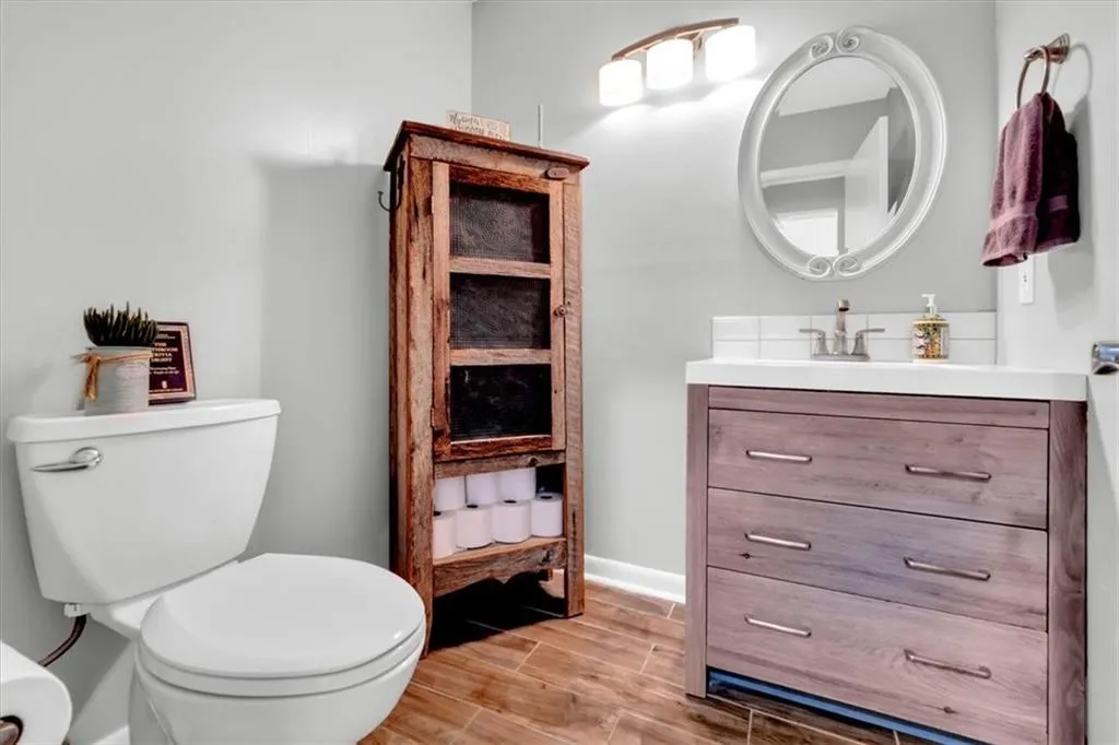 Bathroom featuring wood-type flooring, toilet, and large vanity