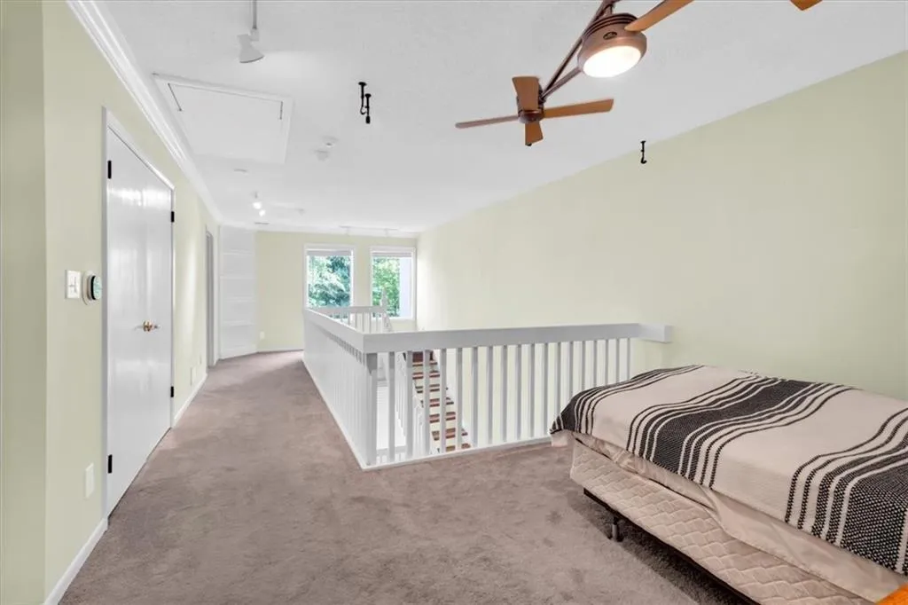 Carpeted bedroom featuring ceiling fan