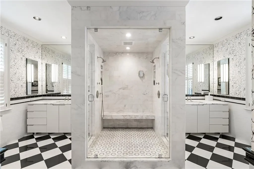 Bathroom featuring crown molding, a stall shower, tile patterned floors, recessed lighting, and two vanities
