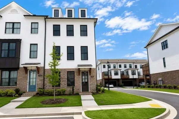 White brick exterior with black framed windows, dark wood bay window, and a teal entry door