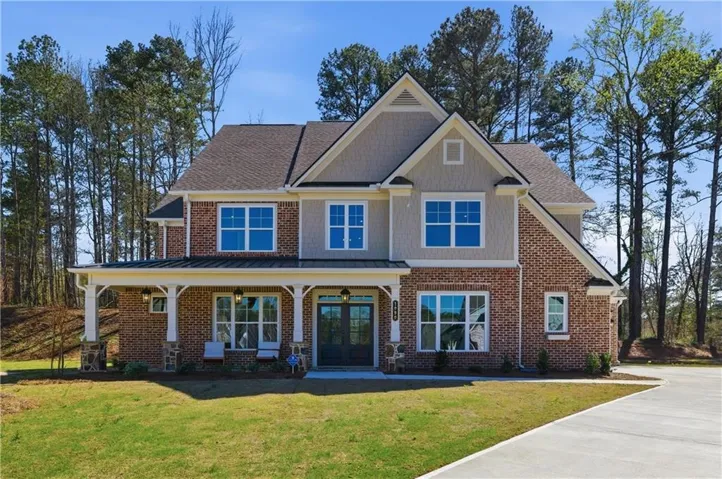 Two-story residence featuring a brick and siding exterior with gabled rooflines