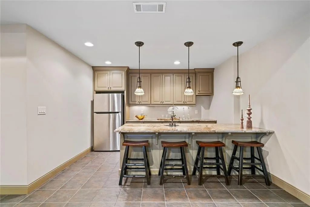 A well-equipped bar and kitchenette include a built-in ice maker, space for a full-size refrigerator, microwave and cabinetry.