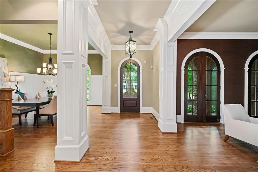 The arched doorways and windows serve as striking architectural focal points, contrasting with the clean lines of the surrounding millwork and columns.