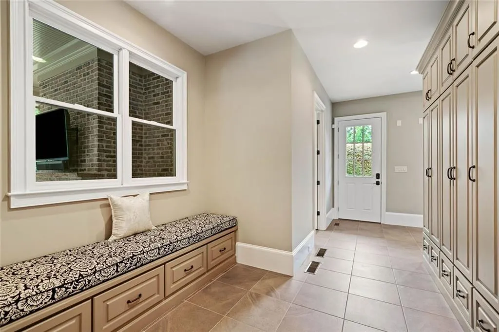 A well-designed mudroom with personal lockers provides the perfect drop zone for coats, bags, and gear while a custom window seat adds extra storage.