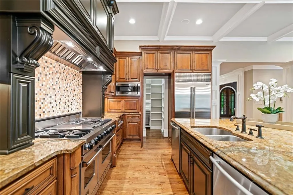Hidden walk-in pantry next to Refrigerator, built-in beverage center opposite the Refrigerator.
