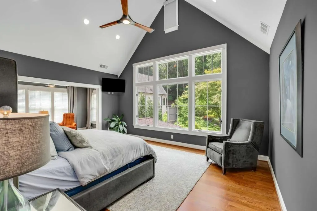 The primary offers sweeping views of the backyard and pool, vaulted ceilings and a cozy sitting area.
