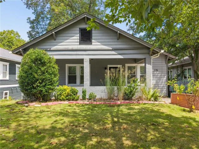 Single-story residence featuring a covered front porch, horizontal siding exterior, and gabled roofline