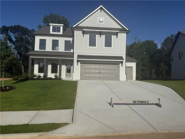 Contemporary exterior with a covered porch, attached two-car garage, dormer window, and an extended concrete driveway
