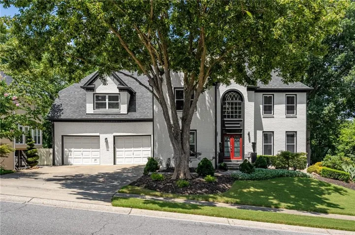 Classic painted brick exterior with mature landscaping, a side entry two car garage, and striking curb appeal in The Fairways at Towne Lake.