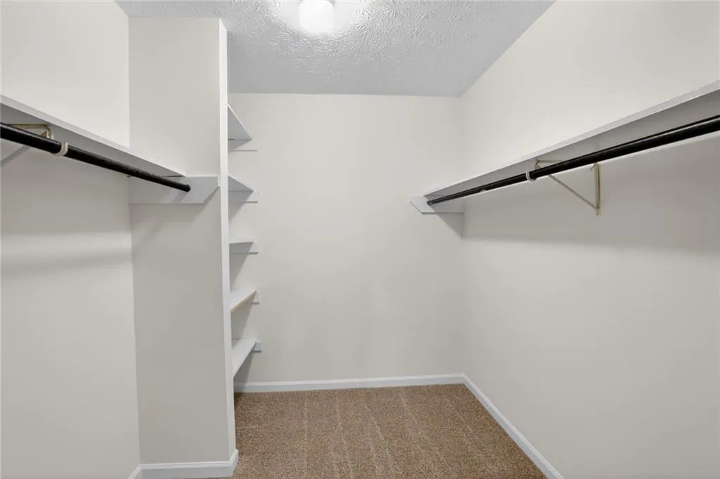 Walk in closet with dark carpet