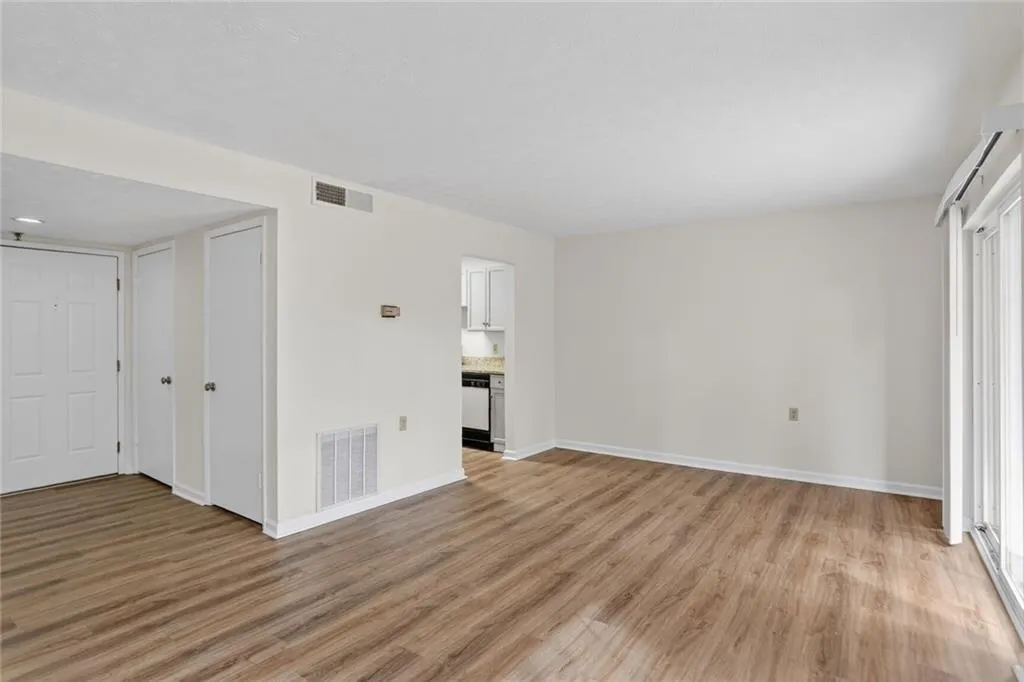 Unfurnished living room featuring light wood-style flooring and baseboards