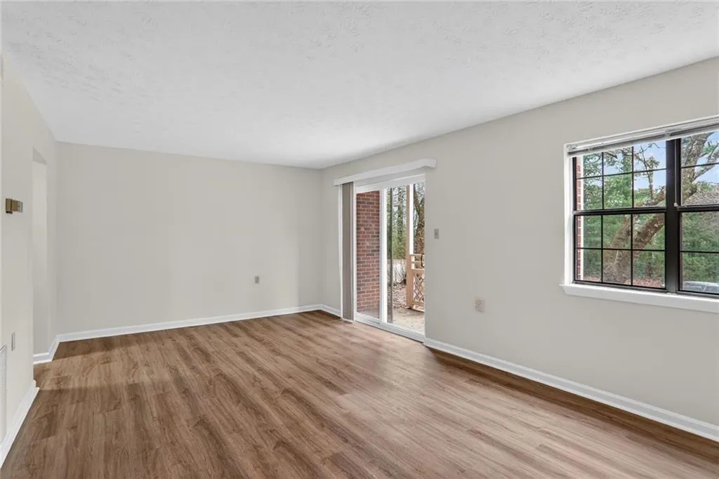 Spare room with light wood-style flooring, a textured ceiling, and plenty of natural light