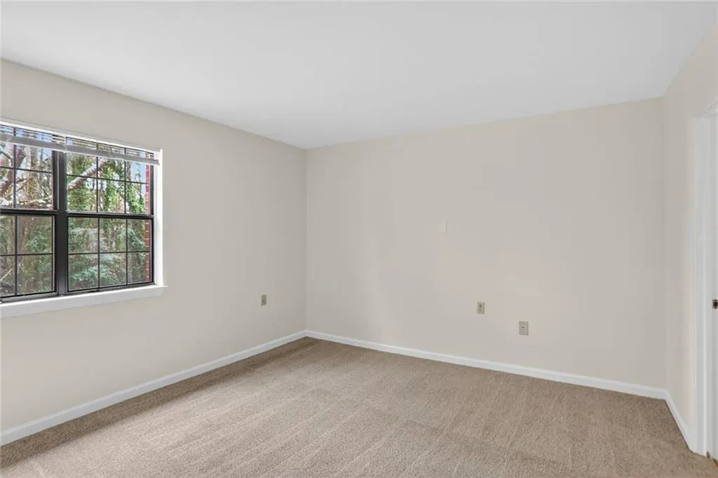 Unfurnished room featuring baseboards and light colored carpet