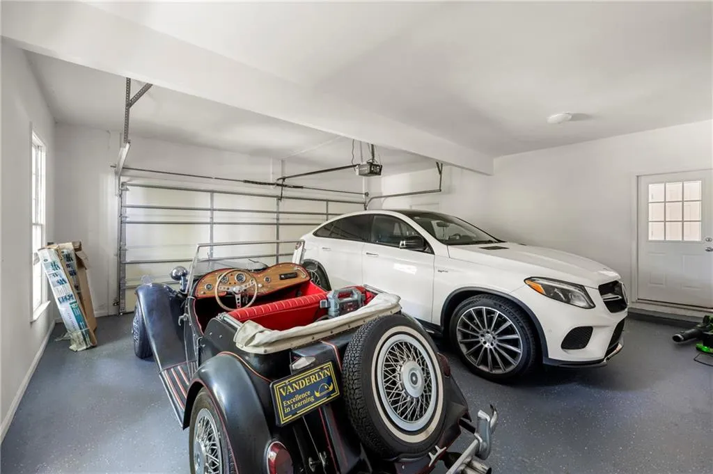 Garage featuring a garage door opener and baseboards