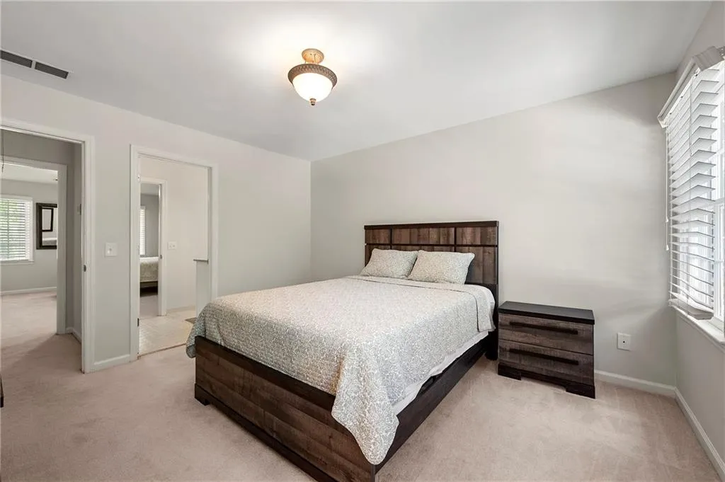 Bedroom with light colored carpet and baseboards