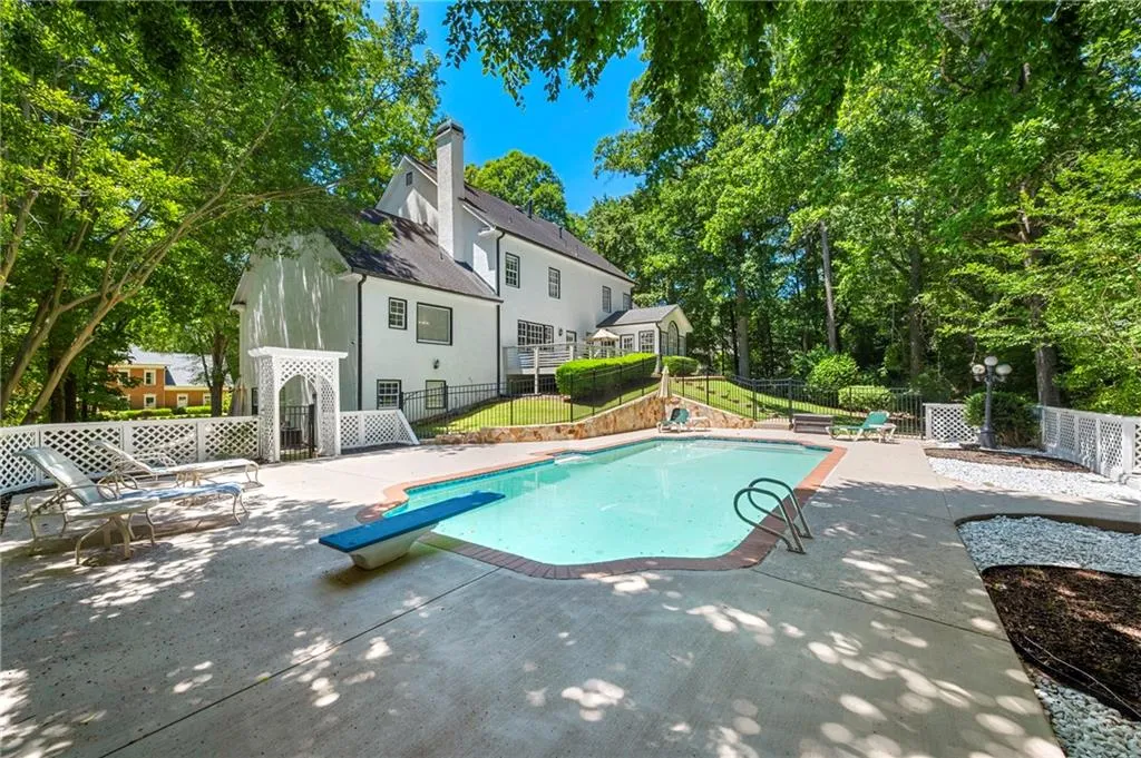 View of pool with a patio and a diving board