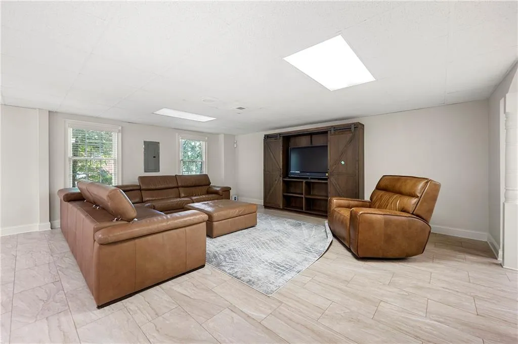 Living room featuring electric panel and baseboards