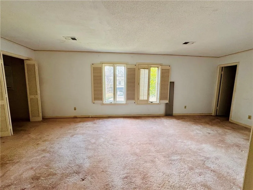 Unfurnished room with a textured ceiling and carpet floors