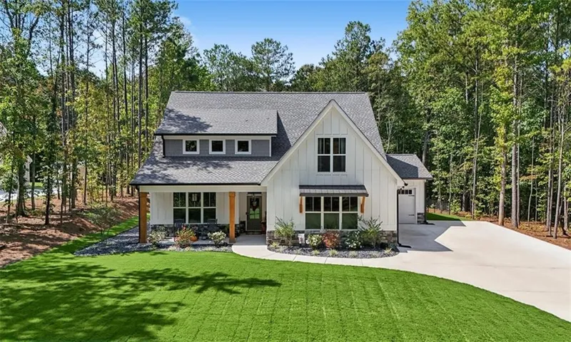 Modern farmhouse exterior with board and batten siding, stone accents, and a grey shingle roof