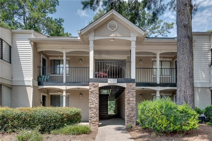 Multi-story building featuring stacked stone accents and a neutral stucco exterior