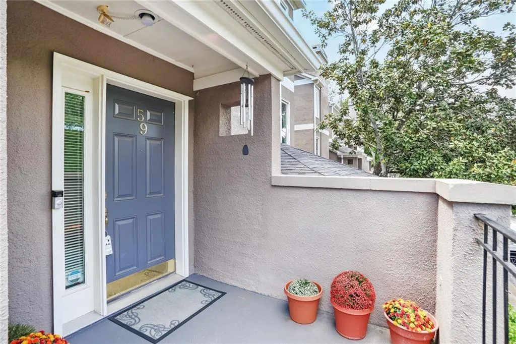 Doorway to property with stucco siding and a balcony