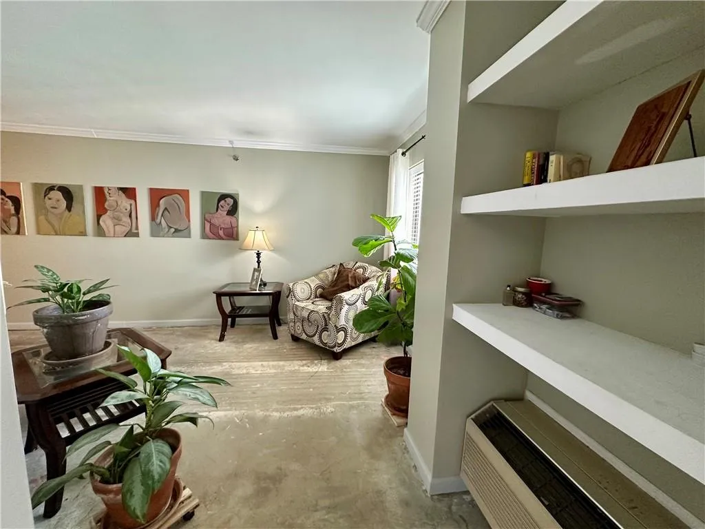Living area featuring baseboards and ornamental molding