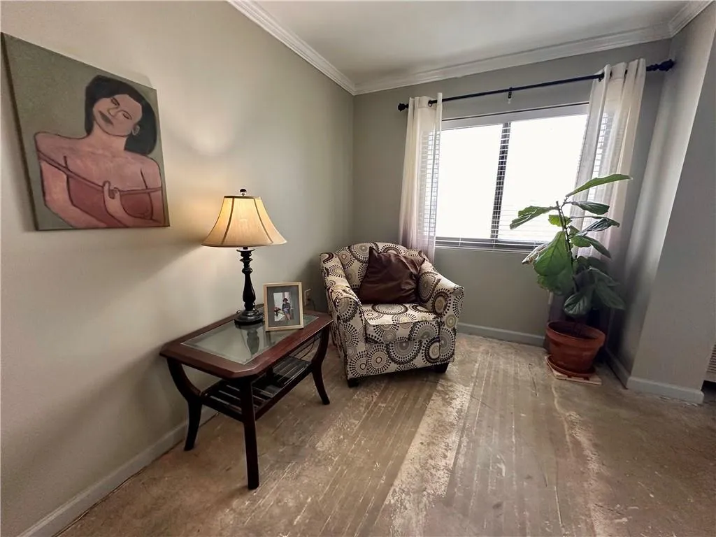 Sitting room featuring crown molding and hardwood / wood-style flooring