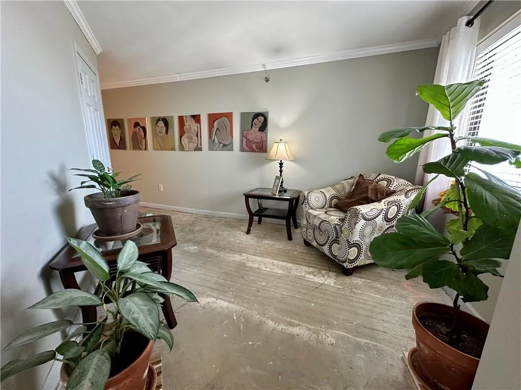 Living area with crown molding and baseboards